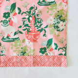 corner detail of a pink chinoiserie tea towel.