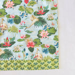 corner view of a floral tea towel from madcap cottage featuring herons and water lilites.