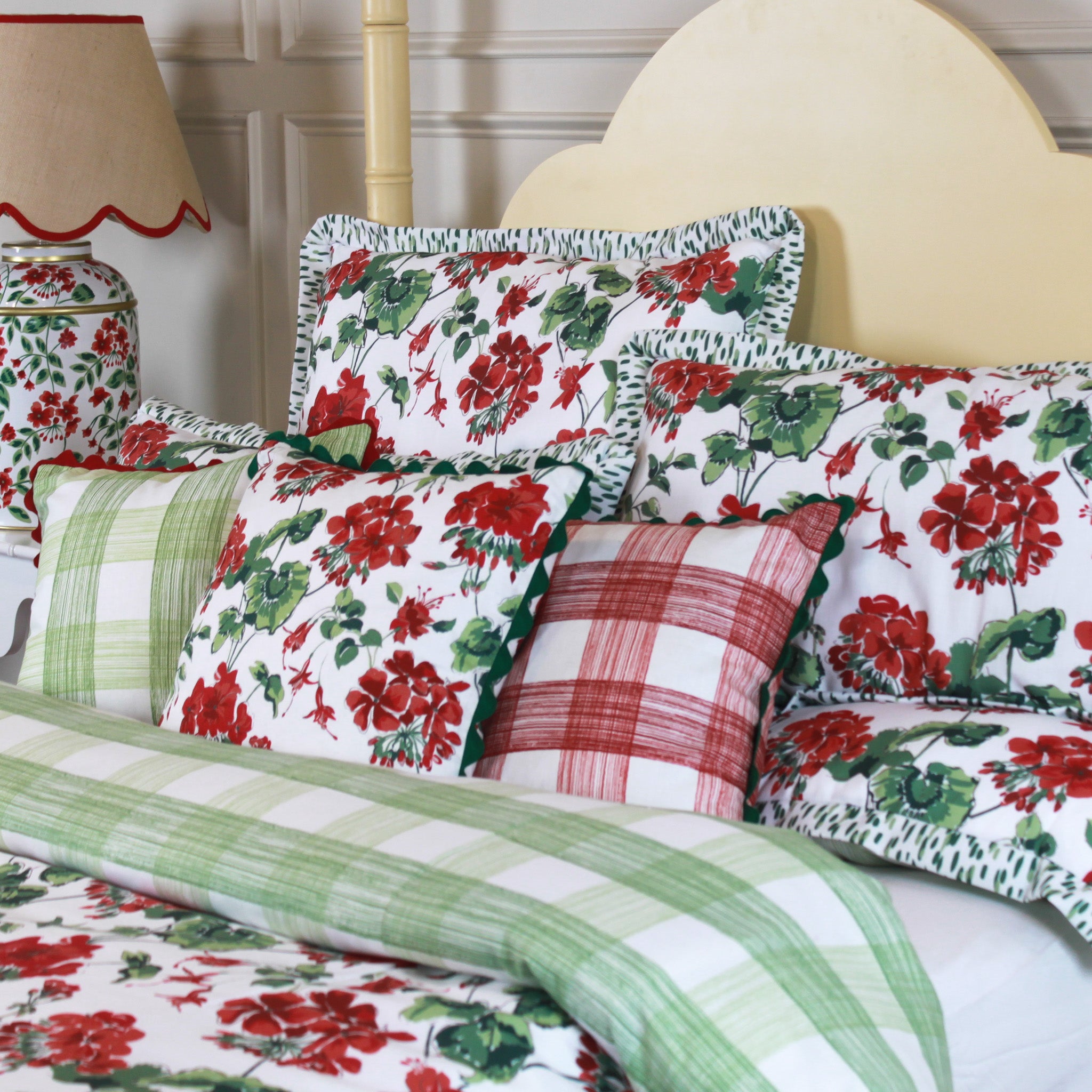 geranium print bedding featuring a reversible duvet with a green gingham reverse side on a yellow canopy bed. 