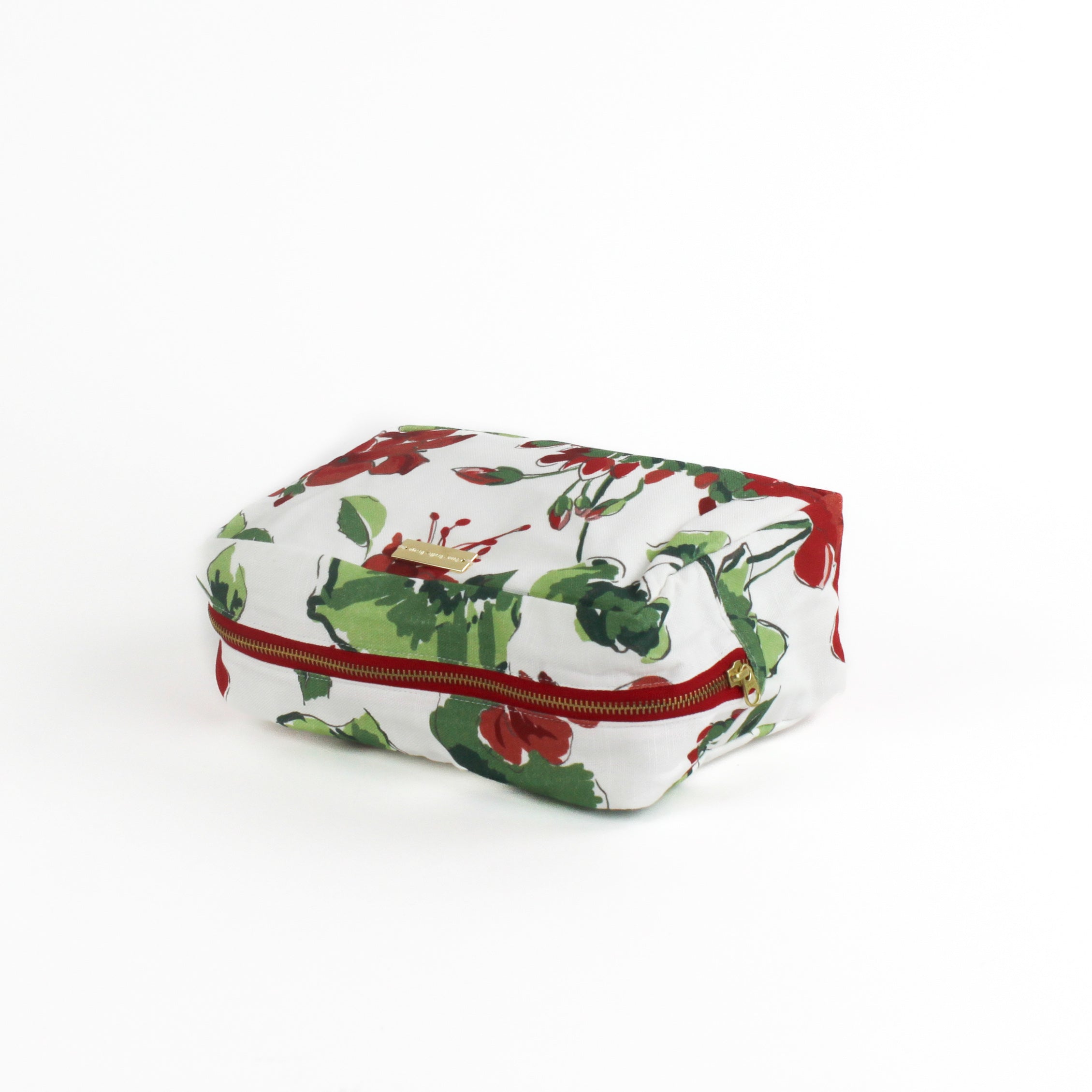 a large Cottage Grove Geranium, a floral toiletries bag with a red, green, and white color scheme, featuring a geranium design.