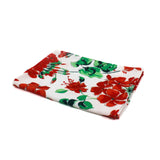 a white floral tea towel featuring a pattern of red geranium motifs against a white background. 