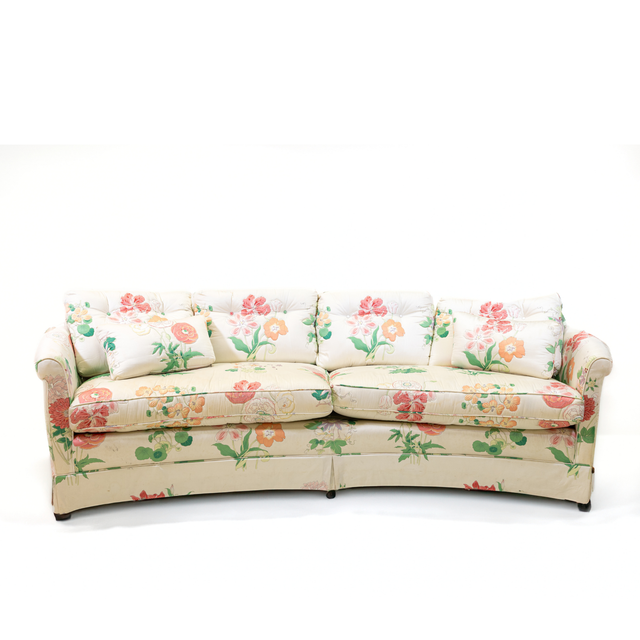 A curved pastel vintage floral sofa