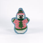 Snowman-shaped decorative pillow with a hooked texture, featuring a smiling snowman wearing a pink sweater with a green Christmas tree design and a matching blue and pink hat.
