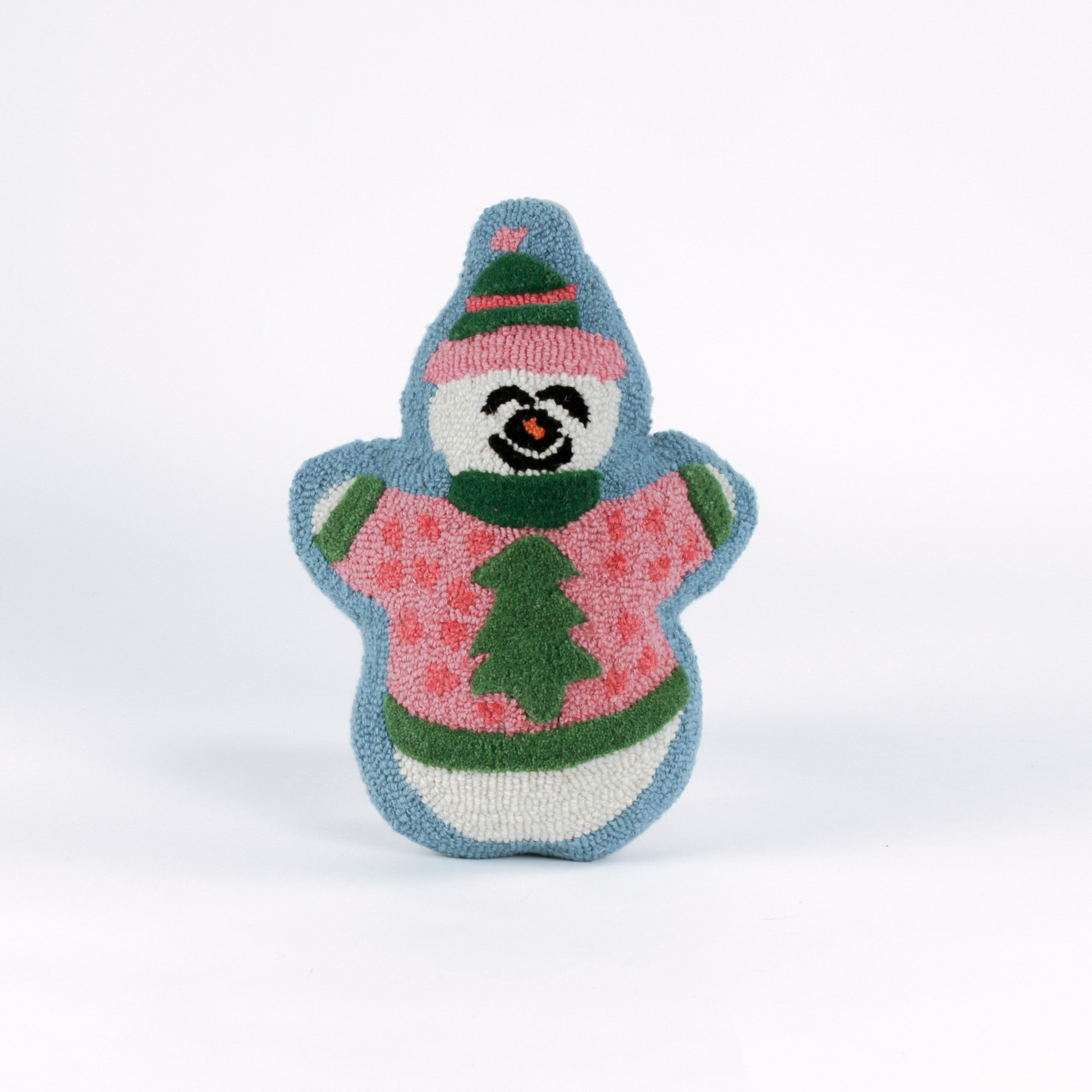 Snowman-shaped decorative pillow with a hooked texture, featuring a smiling snowman wearing a pink sweater with a green Christmas tree design and a matching blue and pink hat.