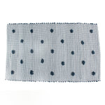 A blue accent rug with a daisies pattern on it