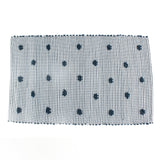 A blue accent rug with a daisies pattern on it