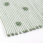 close up of A green accent rug with a daisies pattern on it