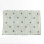 A green accent rug with a daisies pattern on it