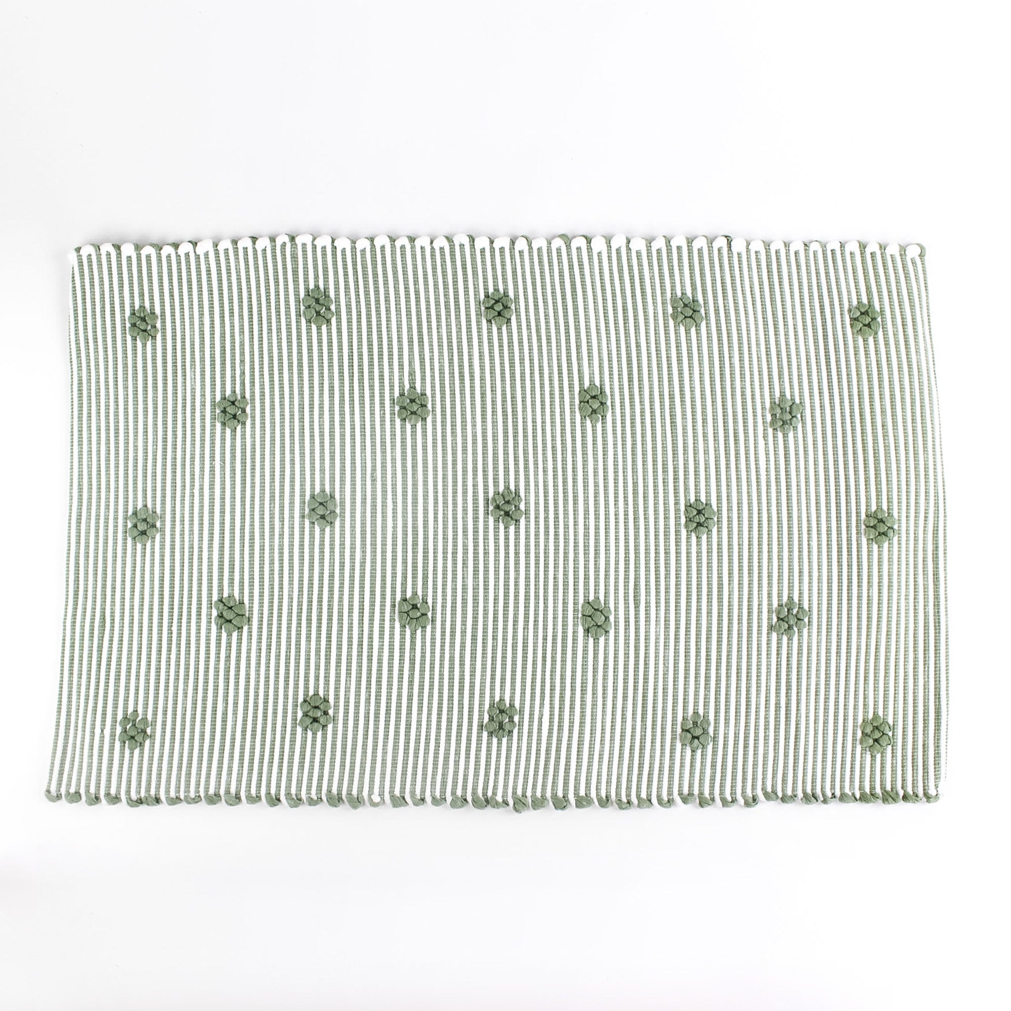 A green accent rug with a daisies pattern on it