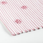 close up of A pink accent rug with a daisies pattern on it