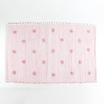 A pink accent rug with a daisies pattern on it