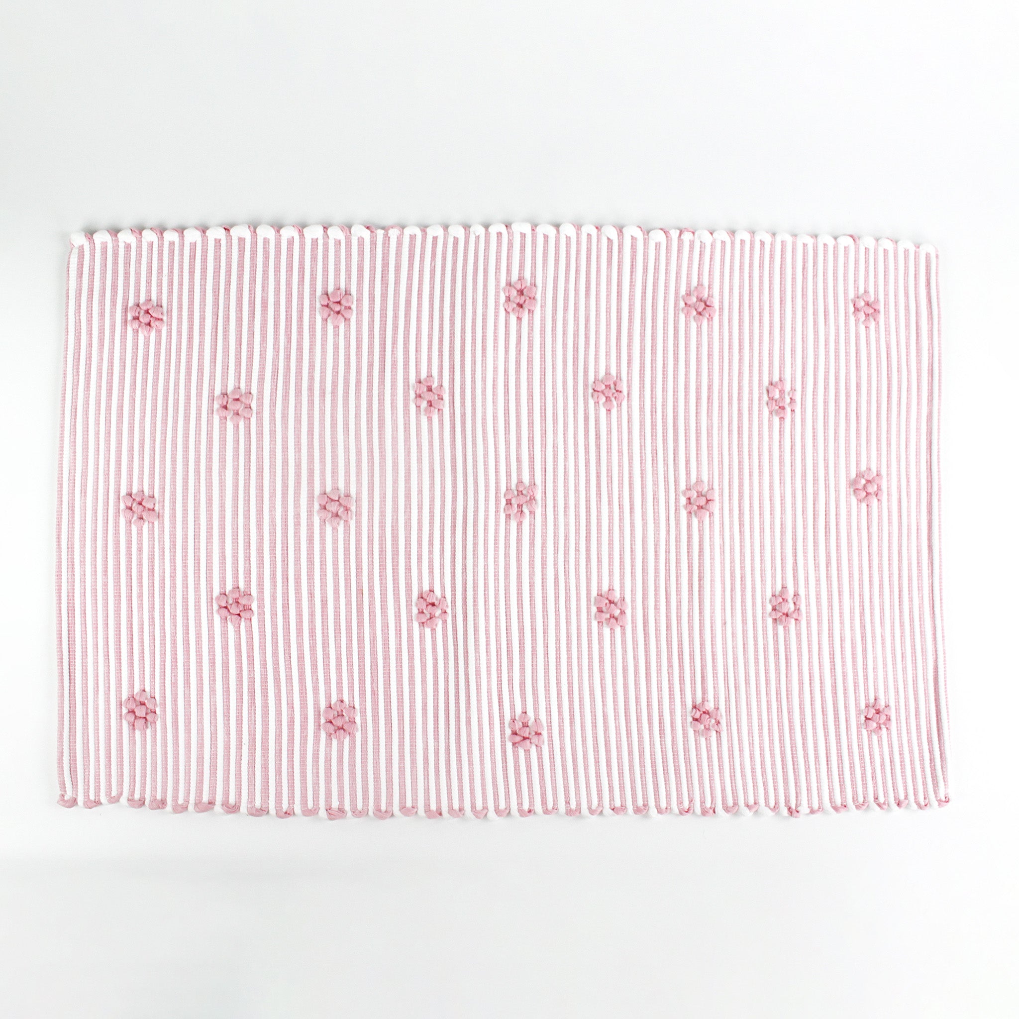 A pink accent rug with a daisies pattern on it