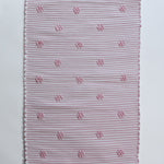 A madcap cottage pink accent rug with small daisy motifs across the front. 