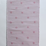 A madcap cottage pink accent rug with small daisy motifs across the front. 