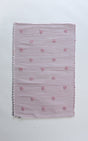 A madcap cottage pink accent rug with small daisy motifs across the front. 