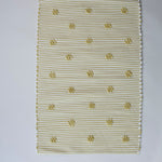 A rectangular yellow accent rug with small daisy shaped accents scattered across it. 