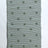 A rectangular green accent rug with small daisy shaped accents scattered across it. 