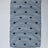 A rectangular navy blue accent rug with small daisy shaped accents scattered across it. 
