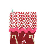 a red candy cane christmas stocking with a red and white blockprint patterned cuff. 