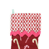 a red candy cane christmas stocking with a red and white blockprint patterned cuff. 
