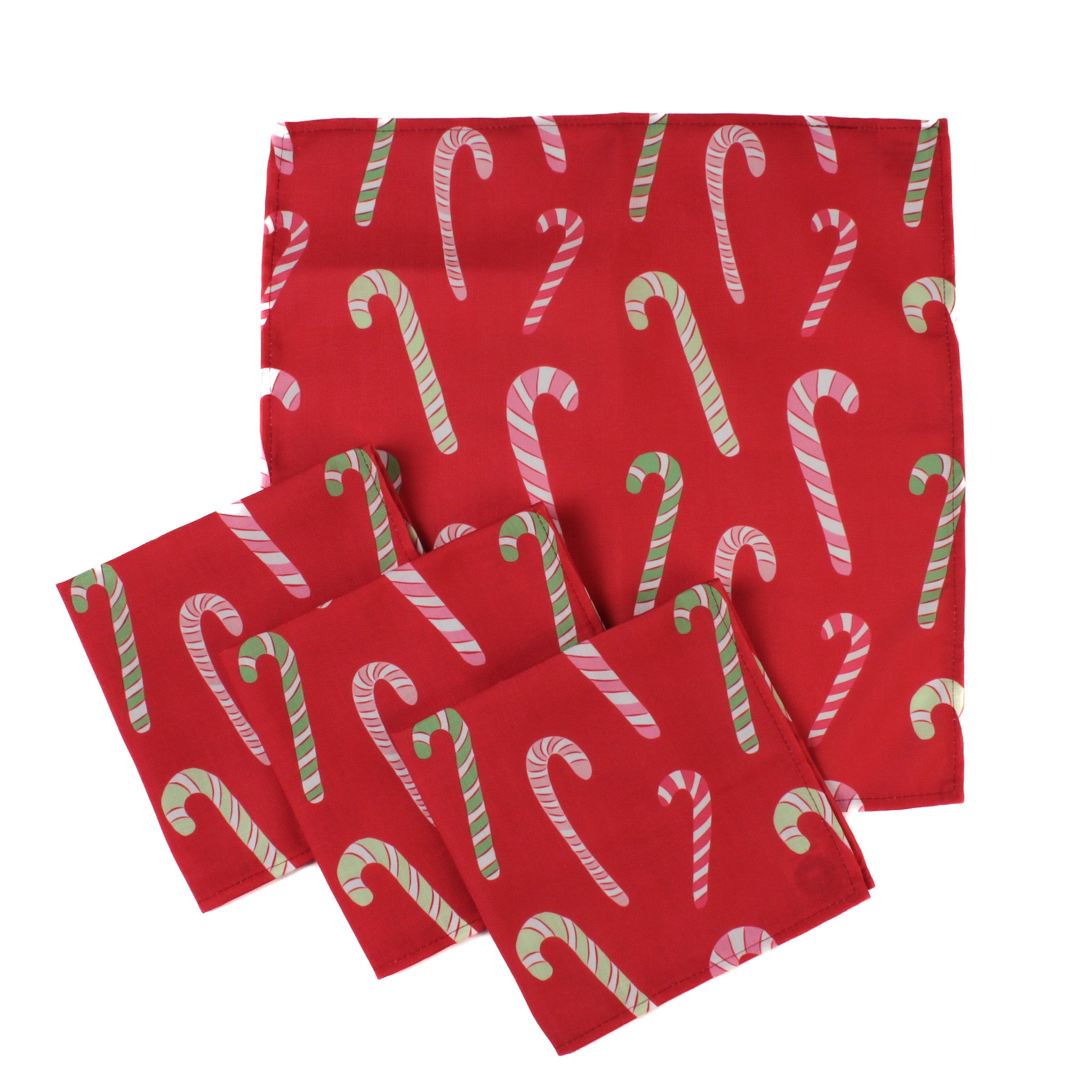 Set of red Christmas dinner napkins featuring an allover candy cane pattern in red, pink, green, and white, neatly stacked with stitched edges, styled for festive holiday table settings and Christmas tea towel coordination.