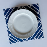 a square blue paper placemats with a white bamboo trellis design called "Island House" from Madcap Cottage.