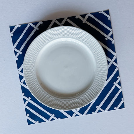a square blue paper placemats with a white bamboo trellis design called "Island House" from Madcap Cottage.