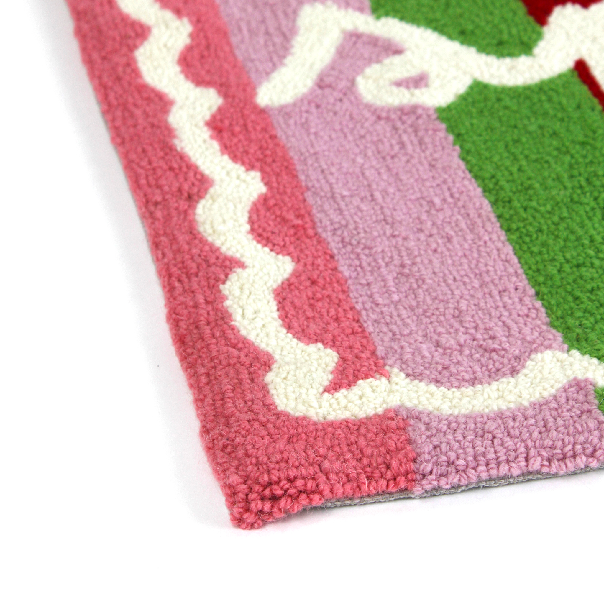 close up details of A striped rectantgular Christmas rug that says "sparkle" and has a white scalloped motif at the border
