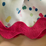 a close up of Springtime confetti multicolor cloth dinner napkin with ric rac trim from Madcap Cottage on a tan background.