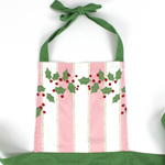 Madcap Cottage Pink and White Striped apron with Christmas designs on a white background close up