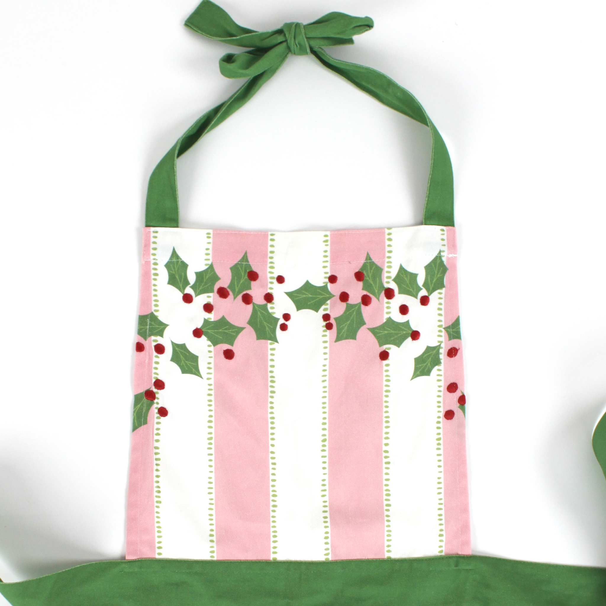 Madcap Cottage Pink and White Striped apron with Christmas designs on a white background close up