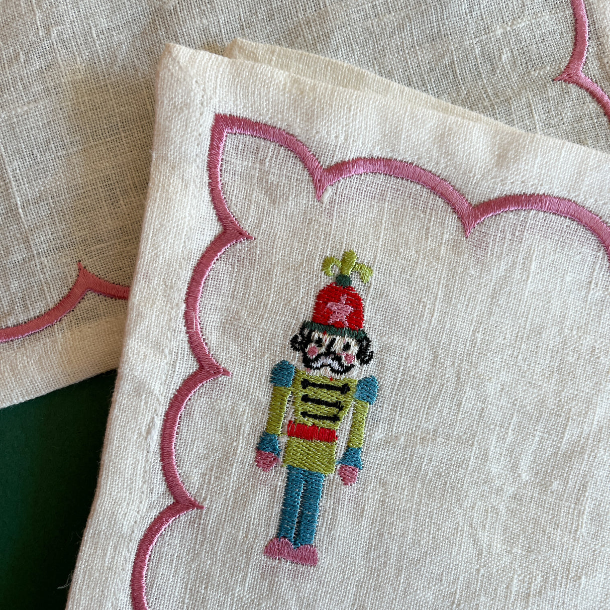Detail of embroidered Christmas nutcracker on a linen cocktail napkin
