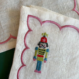Detail of embroidered Christmas nutcracker on a linen cocktail napkin