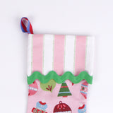 A close up of a pink Christmas stocking with colorful ornaments on a white background