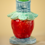 a close up of a strawberry shaped candle holder