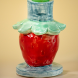 a close up of a strawberry shaped candle holder
