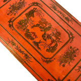 a dark wood chinoiserie side table with two tiers and on rolling casters.