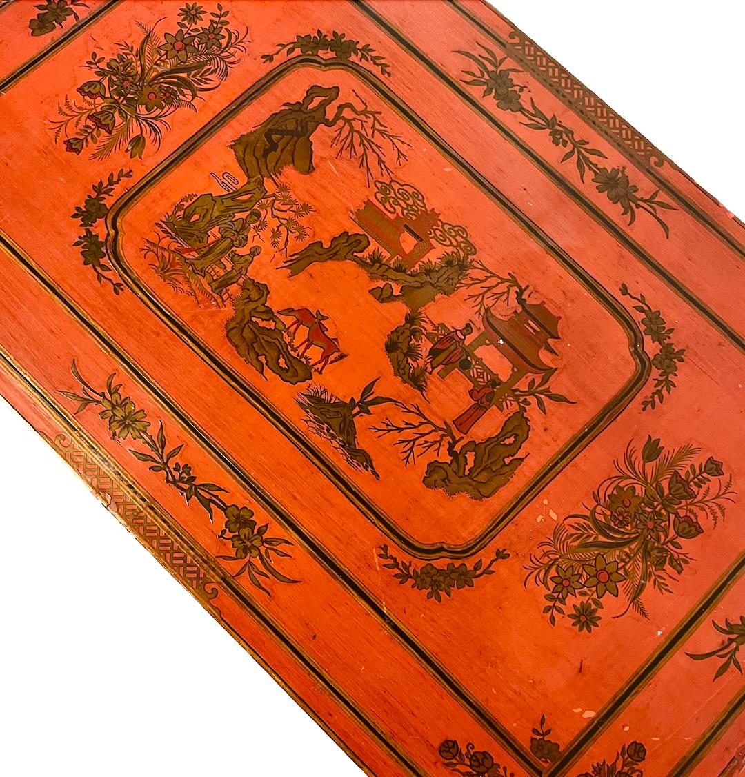 a dark wood chinoiserie side table with two tiers and on rolling casters.