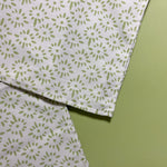 close up of two white and celery green cloth dinner napkin with a painterly motif