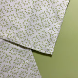 close up of two white and celery green cloth dinner napkin with a painterly motif