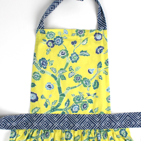 Yellow apron with blue floral pattern on a white background