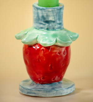 a close up of a strawberry shaped candle holder