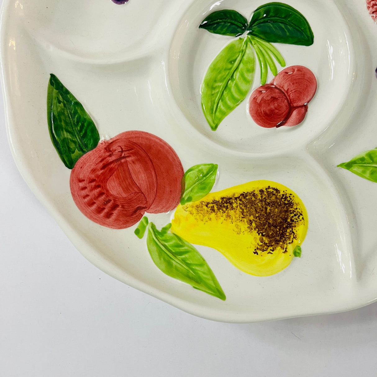 A white vintage strawberry pitcher with strawberry motifs decorating the side