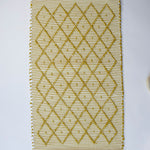 A recycled cotton yellow accent rug with a repeating diamond motif from Madcap Cottage. 