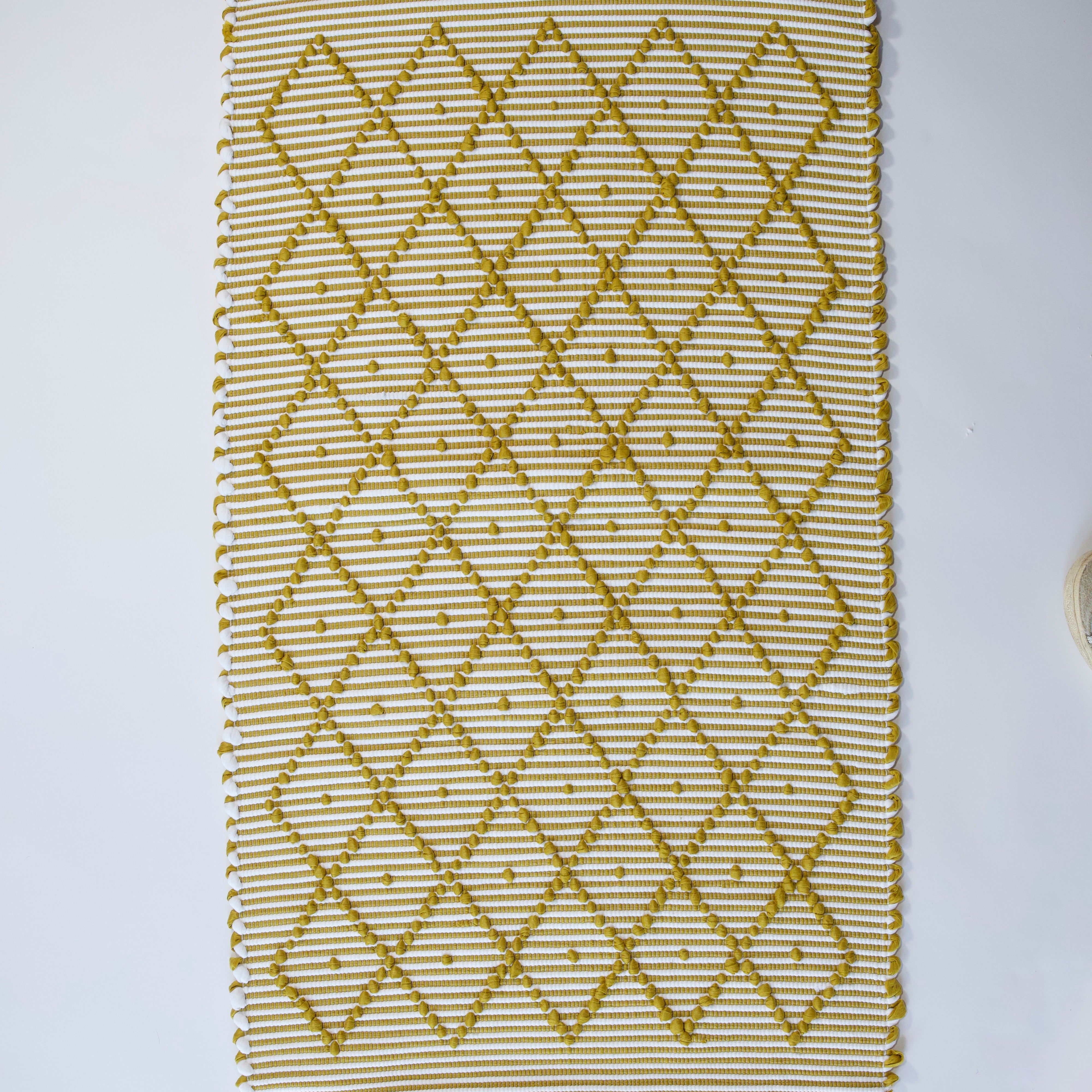 A recycled cotton yellow accent rug with a repeating diamond motif from Madcap Cottage. 