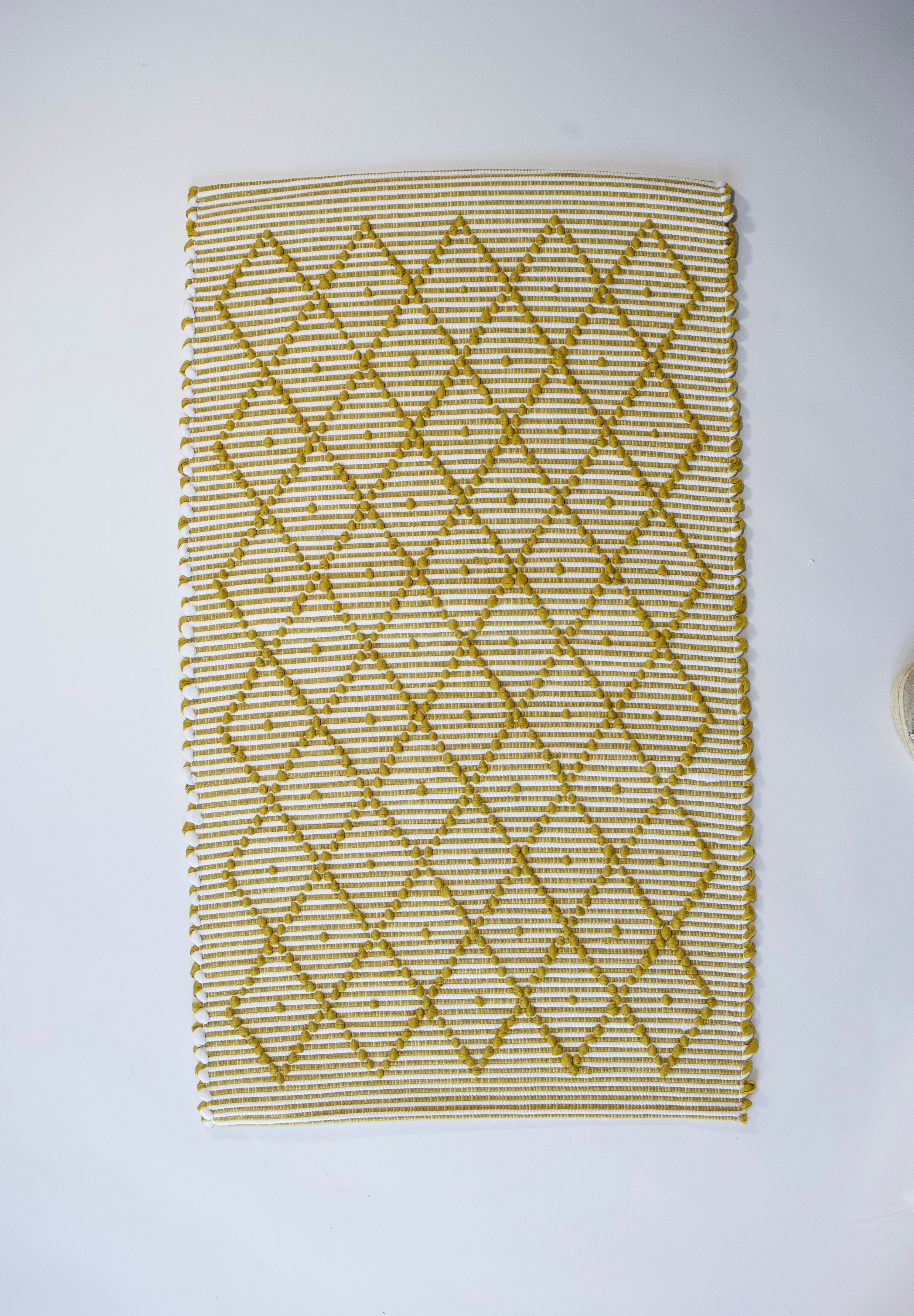 A recycled cotton yellow accent rug with a repeating diamond motif from Madcap Cottage. 