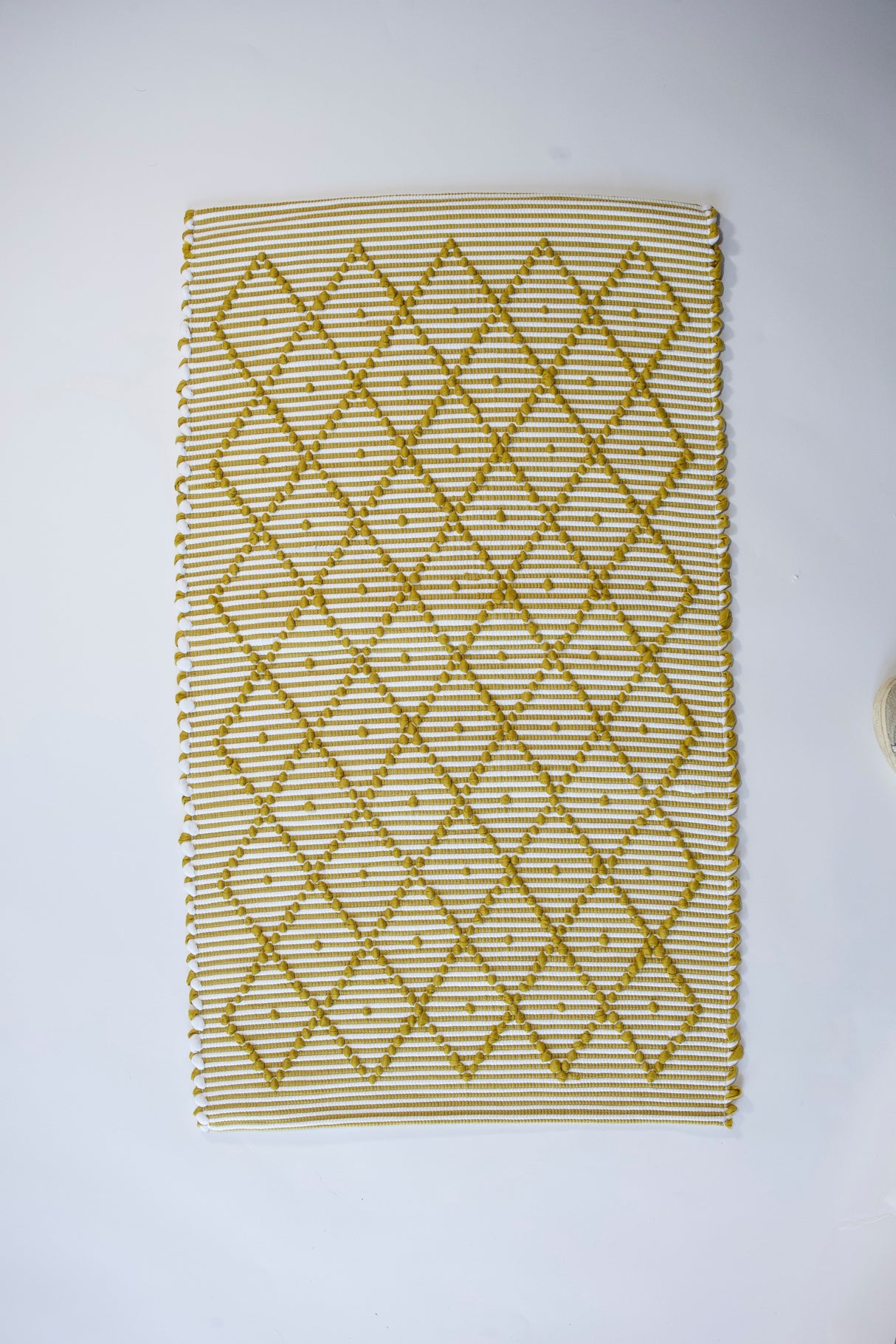 A cotton yellow accent rug with a repeating diamond motif from Madcap Cottage. 
