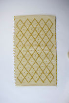 A cotton yellow accent rug with a repeating diamond motif from Madcap Cottage. 