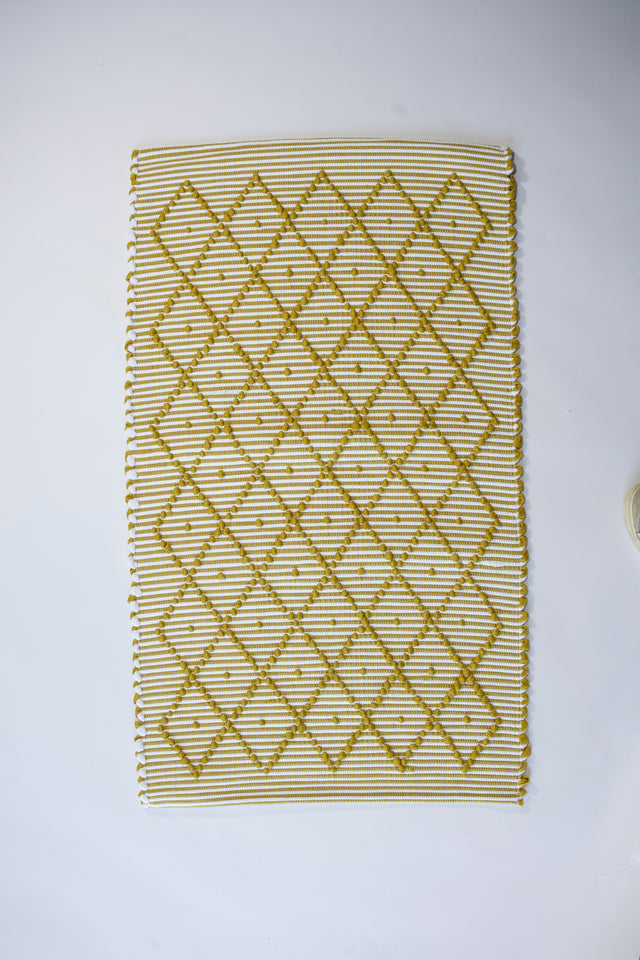 A recycled cotton yellow accent rug with a repeating diamond motif from Madcap Cottage. 