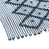 close up look on A blue accent rug with a diamond pattern on it